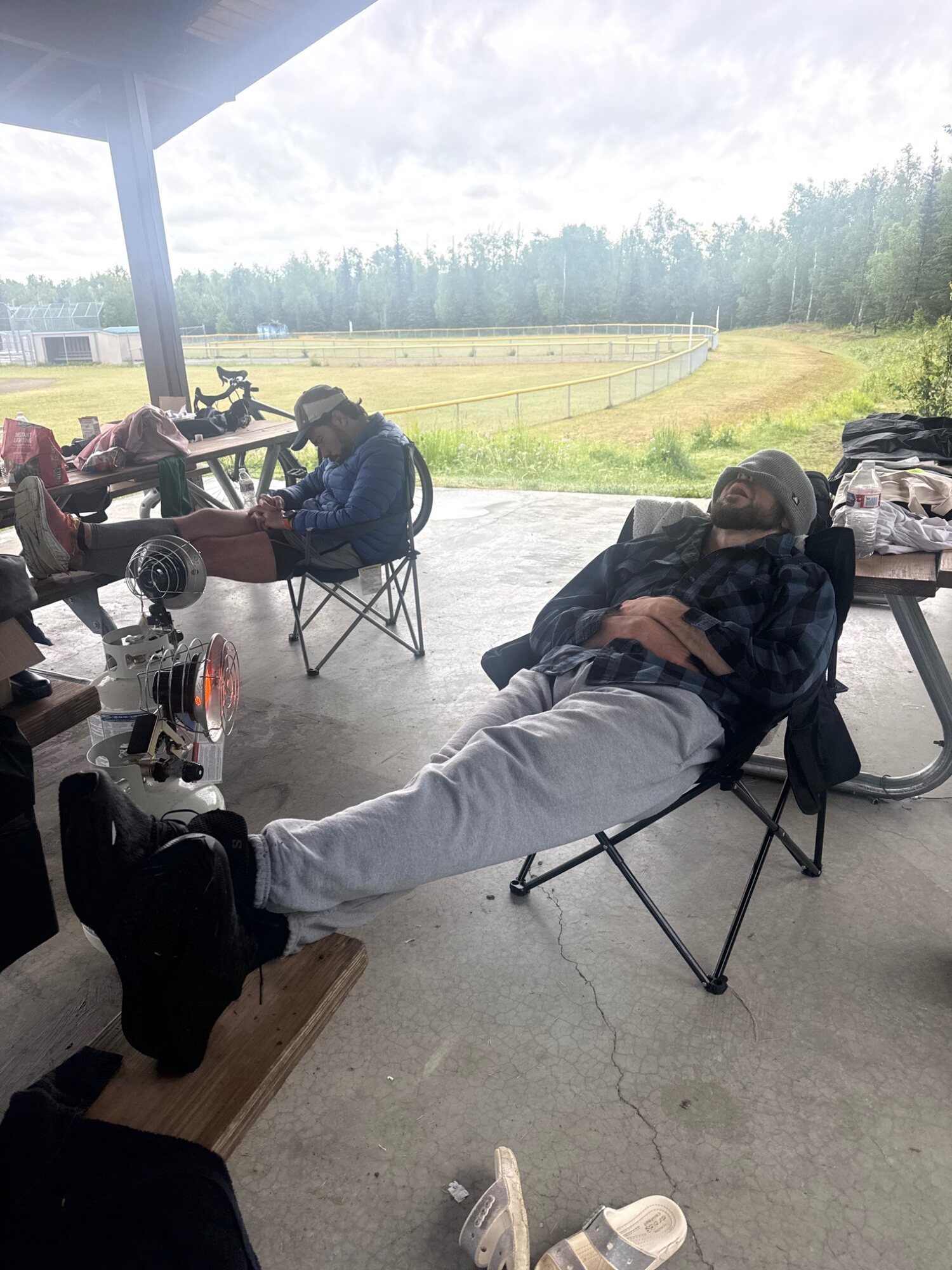 Exhausted participants resting between laps under the event pavilion.