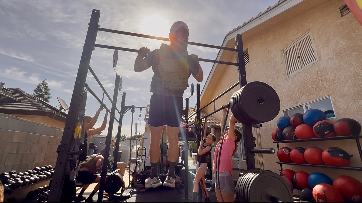 People training together around an outdoor strength rig.